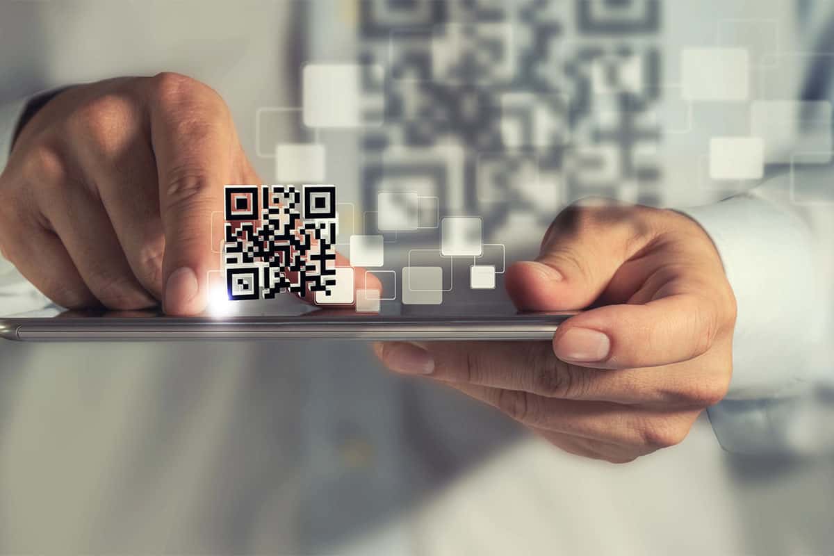qr-code-concept A man scanning a QR code with his phone on San Antonio promotional products.